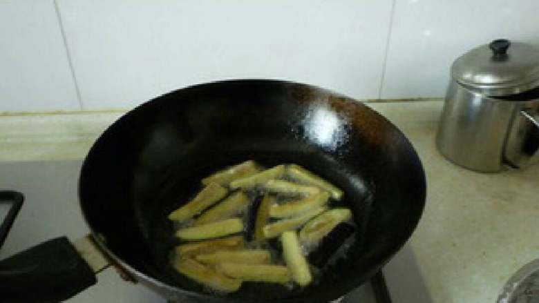 油焖茄子,5.锅中放油，油热后将茄子入锅
炸成黄色

