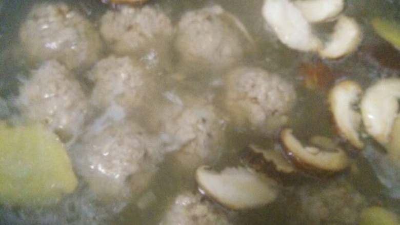 香菇肉丸汤,水再次烧开后加入香菇片，姜片，再盖上锅盖煮。