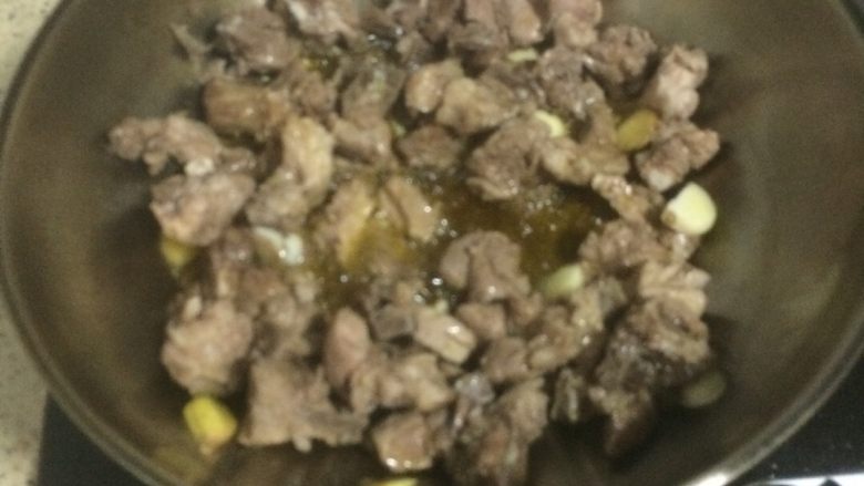 私房排骨，土豆和排骨是绝配哦,烧排骨要多倒一些油，然后把冷却的排骨倒入锅里，加入姜蒜，开小火爆一下。