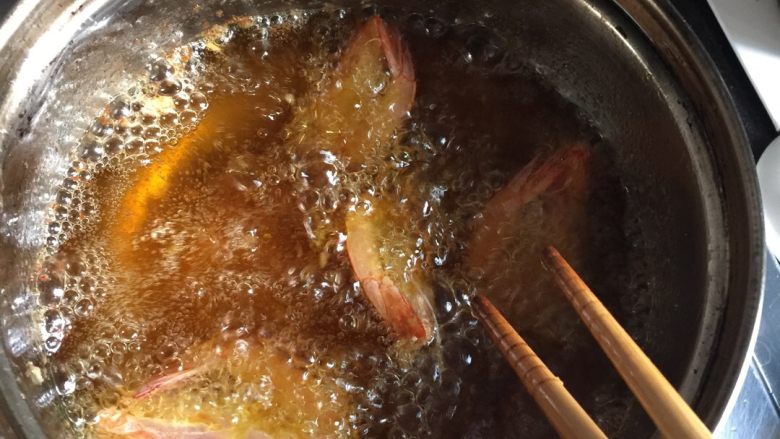 和虾来约会1------避风塘虾,待油温升到7成热，放入虾，炸2-3分钟，表皮酥脆就可以了。因为是小锅，所以这么虾分成三锅炸好！取出吸油备用！