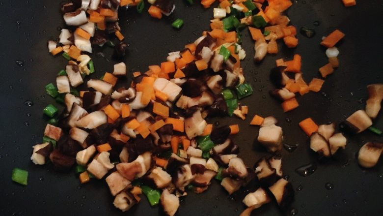 香菇酱拌茄子,放香菇和胡萝卜丁，翻炒几分钟