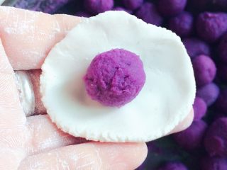 紫薯汤圆,把糯米球压扁，捏薄皮，在中间放上紫薯，然后包好