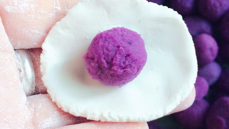 紫薯汤圆,把糯米球压扁，捏薄皮，在中间放上紫薯，然后包好