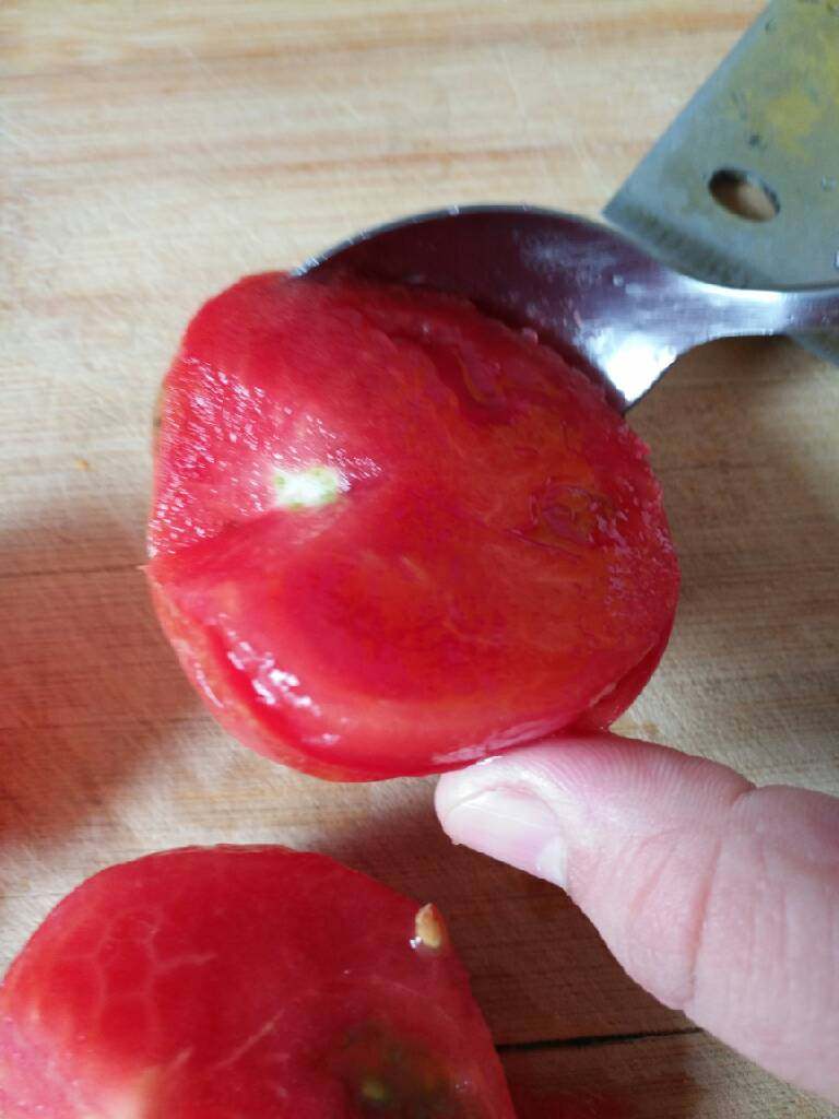 西红柿炒鸡蛋,柿子一切两半，去掉根，用勺子贴边去皮