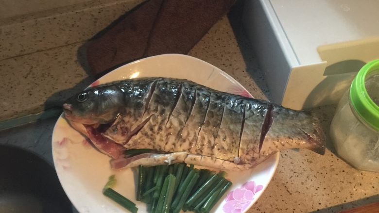 红烧白鲫鱼,清水清洗一遍特别是鱼头亮片，鱼肚子里面的黑色，然后划口上面抹稍稍的盐巴