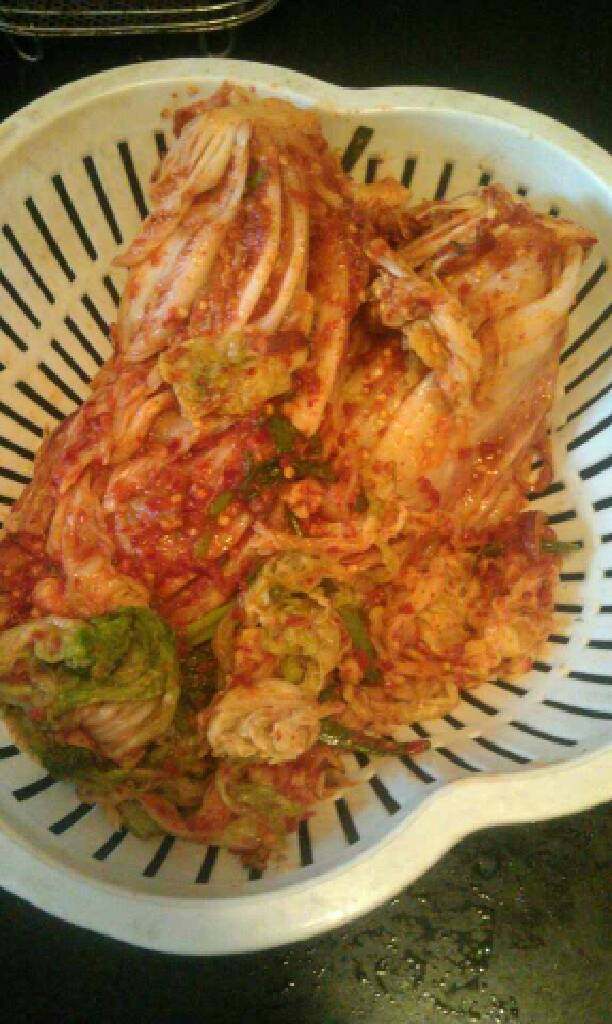 韩国泡菜,挤干叶子上的水，把每一张菜叶都均匀的抹上做好的调料