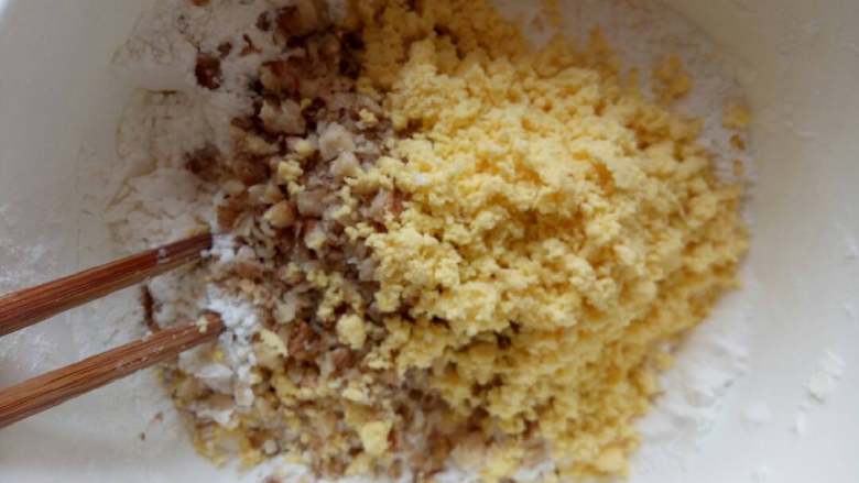小饼干,将蛋黄粉末，和坚果碎导入面粉盆中搅拌