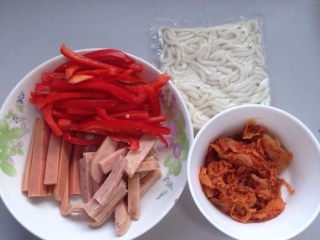 辣白菜乌冬面,备料：红椒切丝，火腿肠切条，午餐肉切条。辣白菜弄出来放碗里，备用！