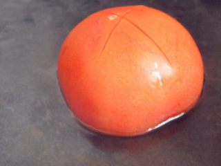 番茄龙利鱼,番茄顶部用刀划十字，放在热水中烫一下去皮。