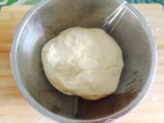 肉松麻花面包,取出后揉搓一下后，放入盆里盖上保鲜膜，静置半小时或一小时（根据季节调整），等待面团进行二次发酵