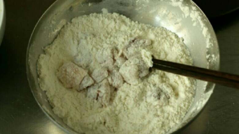 烤鸡米花,用筷子拌一拌肉丁直至全部粘上面粉，以此类推把所有的肉丁都粘好面粉