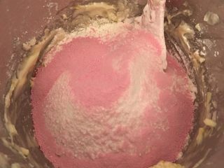 草莓奶香曲奇饼干,然后将高筋面粉，玉米淀粉，奶粉，草莓粉过筛加入黄油糊中