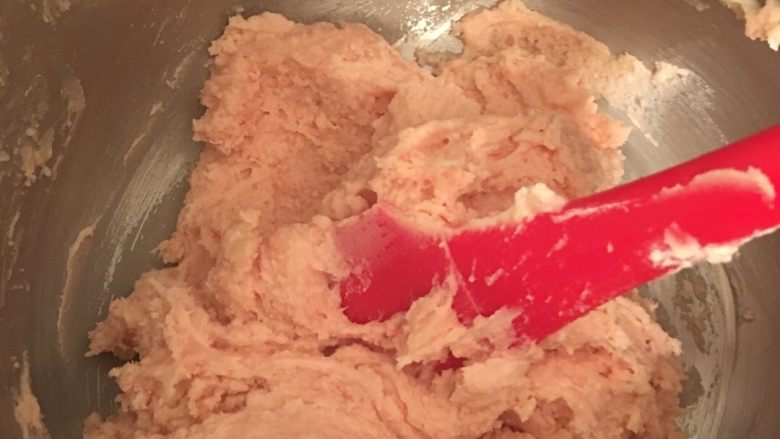 草莓奶香曲奇饼干,用刀刮将粉于黄油糊完全混合均匀