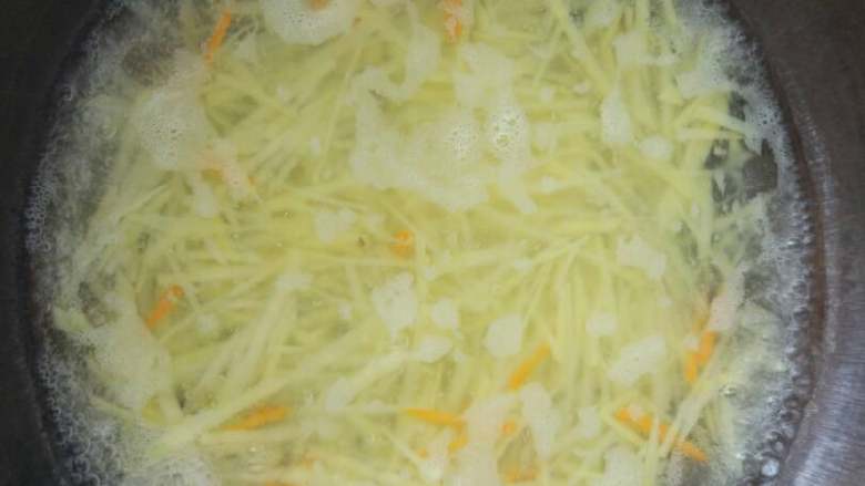 酸辣土豆丝,锅里添水烧开，放入胡萝卜丝和土豆丝。土豆丝焯水前多洗几遍，可以更清爽，更脆。
