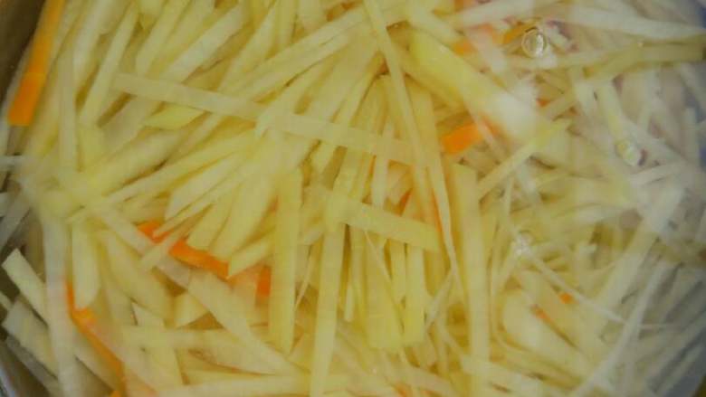 酸辣土豆丝,水再次烧开后，将土豆丝和胡萝卜丝捞出，彻底冷却备用。