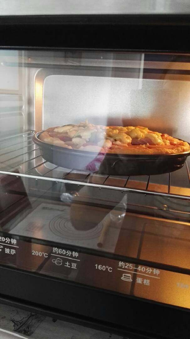 披萨,烤箱预热5分钟左右，然后将披萨放入烤箱，上下管均200℃，20分钟即可