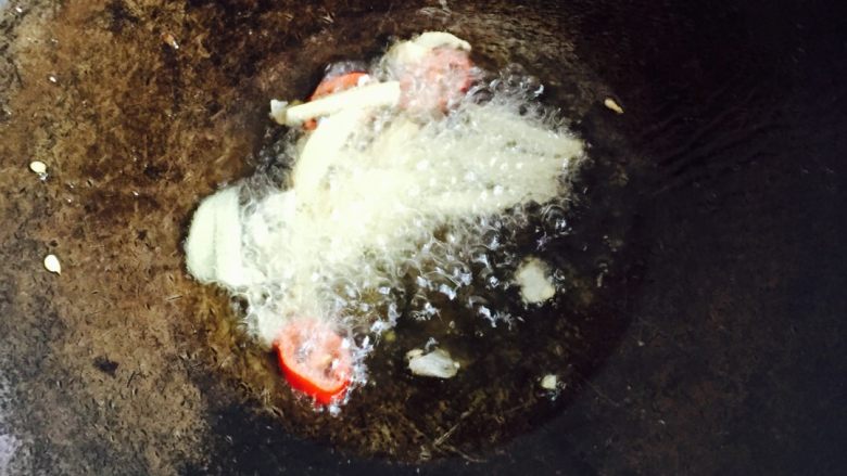 爆炒河虾#有个故事#,食用油倒入炒锅加热，放进姜丝、大蒜、朝天椒煸出香味