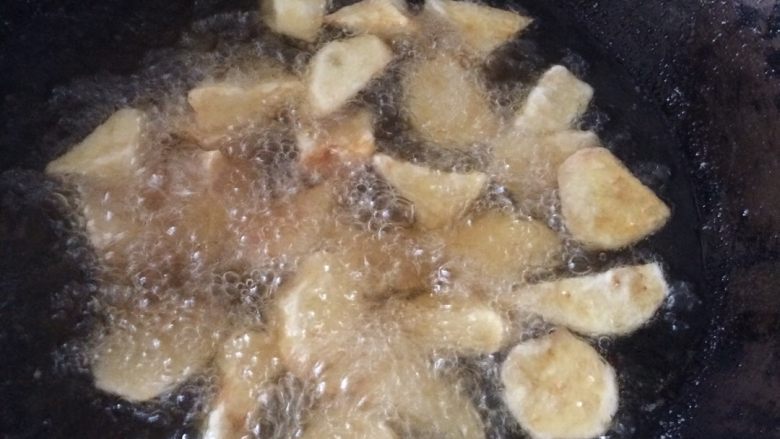 拔丝土豆（土豆变身了）,炸到用筷子扎得进土豆时，证明土豆已经熟了，捞出，把油再次加温，冒烟时，二次炸土豆，