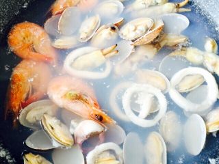 西班牙海鲜饭#有个故事#,把海鲜洗净倒入锅中、加适量清水和盐、少许白葡萄酒煮开