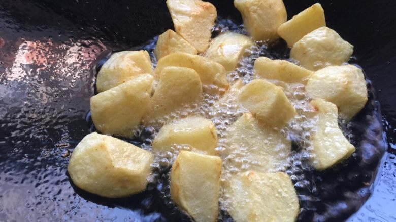 牛杂土豆煲,热锅放油烧热，放土豆快速翻炒，土豆炸至变硬身，如图。