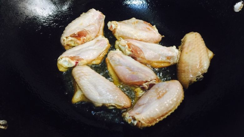 鸡翅焖饭,锅里加热放橄榄油，用小火煎鸡翅，煎至两面金黄。