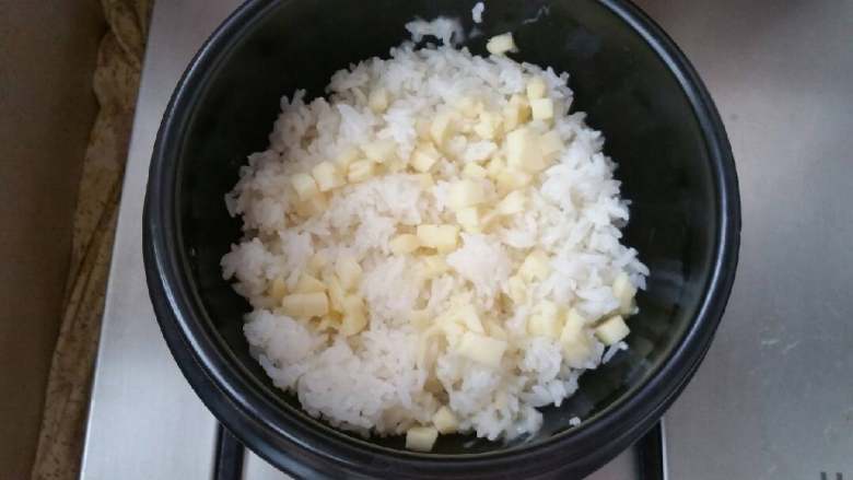 石锅芝士海鲜拌饭,放入米饭，米饭上再撒一层芝士碎。