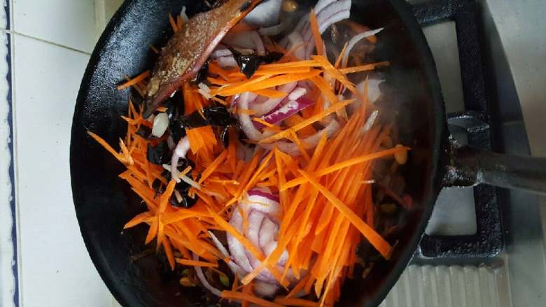 家常剁椒咸菜丝,等水分差不多蒸发以后，放入胡萝卜丝葱头丝。放早了葱头容易烂。