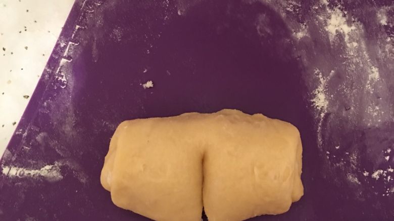 椰蓉馅奶香面包,然后在卷好后的椰蓉面团上，中间部分划一刀