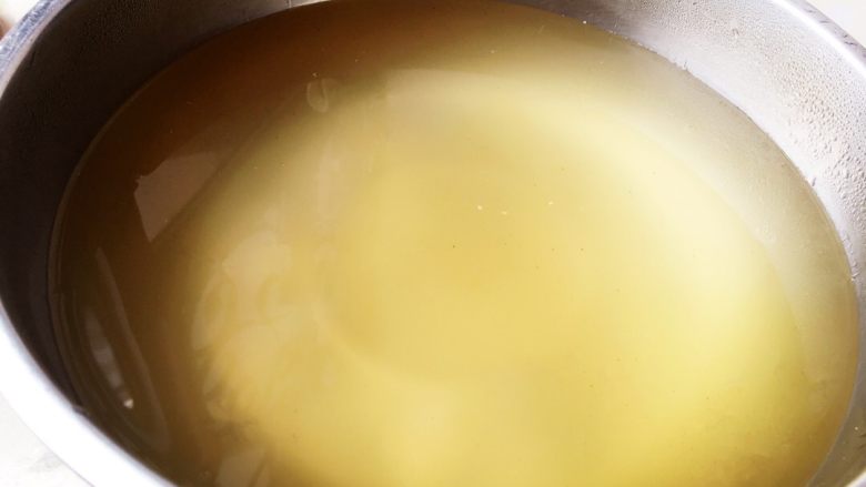 冰粉,将表面泡沫用勺子滤去，将澄清过的石灰清水倒入盆里，快速均匀搅拌浆液。