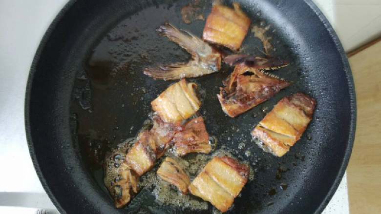 香煎咸鲅鱼,煎至鱼的两端微微翘起，翻面。此时，一面已经煎至金黄色了。翻面后再煎两分钟。