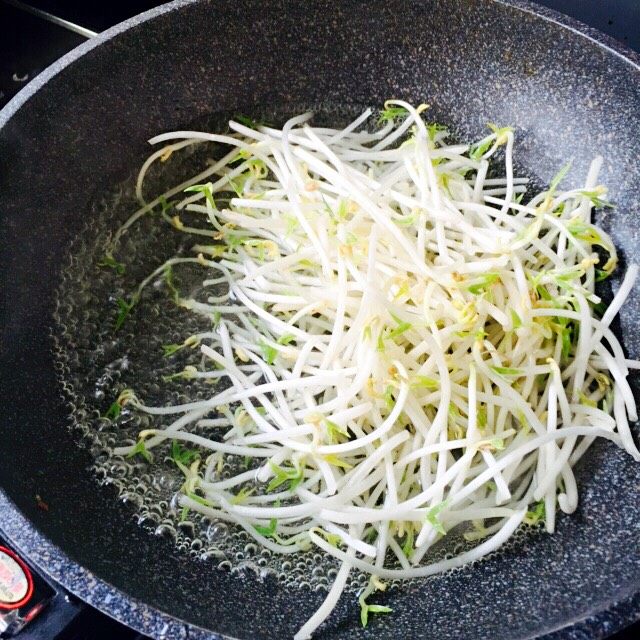 醋溜绿豆芽,锅里倒入适量的清水烧开加一勺盐、把洗净的绿豆芽放入锅里焯水