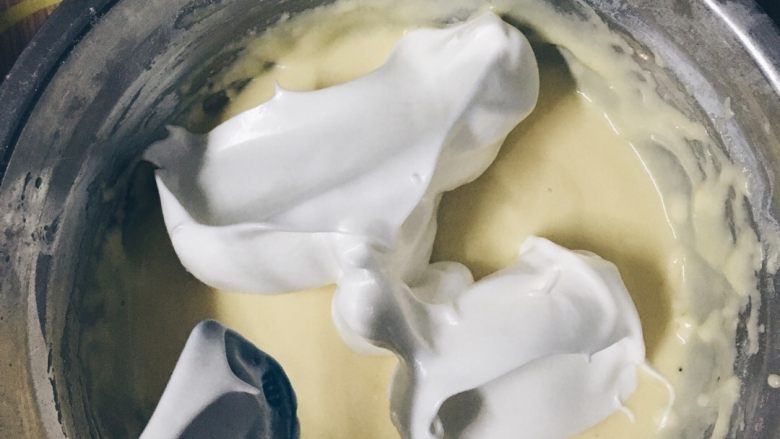 酸奶戚风蛋糕,取1/3打发的蛋白霜与蛋黄糊用刮刀搅拌均匀。