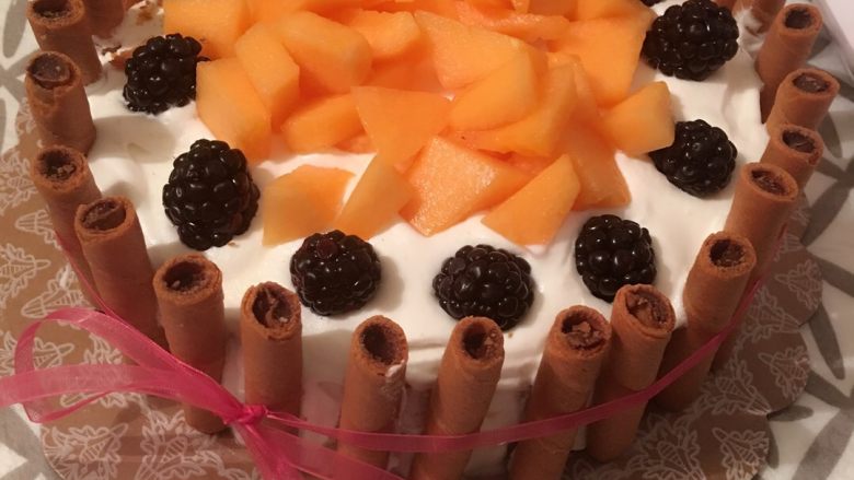 水果蛋糕,最后铺上喜欢的水果，再蛋糕周围摆上巧克力蛋卷或者手指饼干。