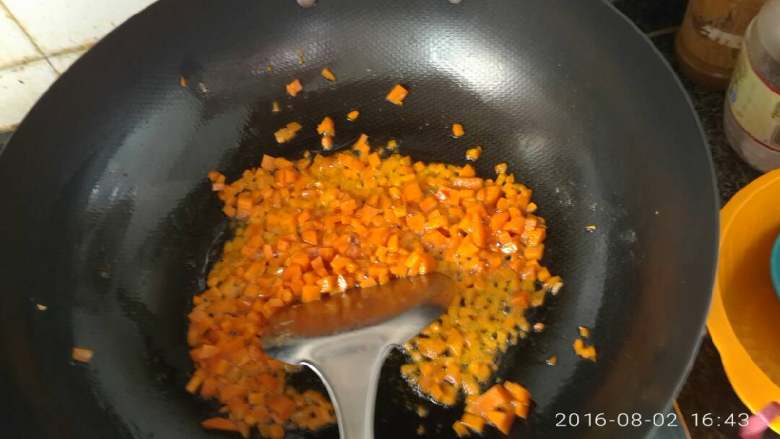 鸡肉果蔬营养粥,放入事先准备好的胡萝卜丁。编炒至金黄。