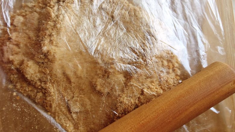 面包糠,用擀面杖碾碎吐司粒。