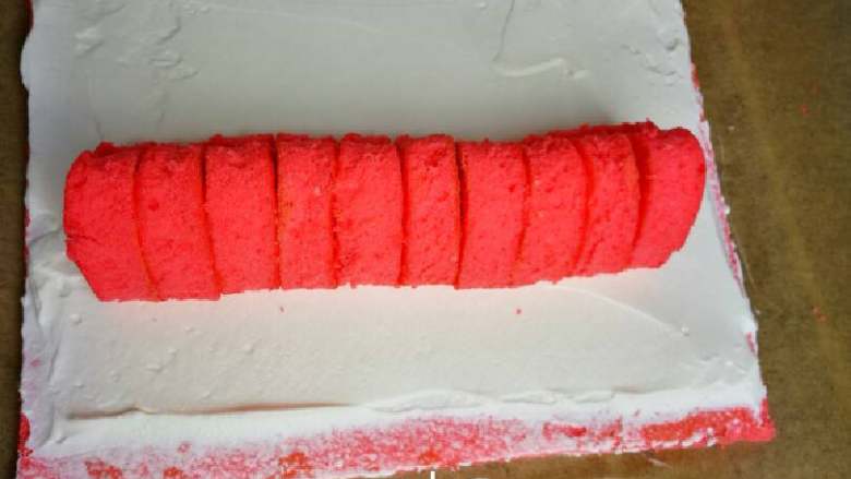 织女也疯狂 — 【爱心蛋糕卷】,将打发好的淡奶油均匀的抹在蛋糕上，注意上下收口部分各留1cm，以防奶油溢出。放上爱心海绵蛋糕。