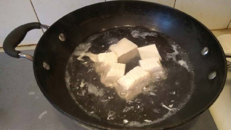 咸蛋黄豆腐,锅里放水500克烧沸，放入豆腐，中火煮五分钟。豆腐容易碎，轻拿轻放。捞出沥干待用。