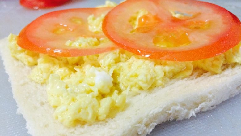 简易三明治,将鸡蛋放在锅内，大火煮30秒内即可，（记得搅拌）否则会糊掉。
将煮好的鸡蛋铺在方包上，在放上切好的西红柿。