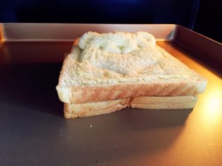 小熊牛油果三明治,把造型吐司放在上面，放入烤箱180度，上下火，中层5-8分钟，直至有点上色。