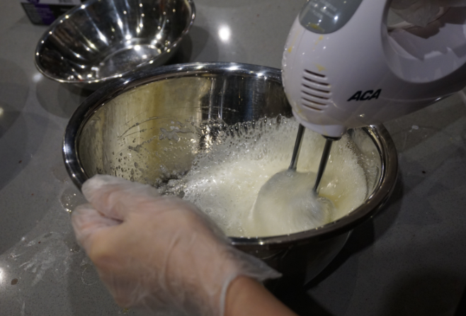 红丝绒蛋糕卷,把糖分次加入蛋清，用电动打蛋器先低速打发蛋白，出现粗泡时用高速进行打发