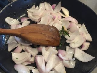 法式迷迭香烤小羔羊排,锅清洗擦干后再次倒入适量橄榄油，放入洋葱翻炒出香味，再倒入香料碎稍微炒一下