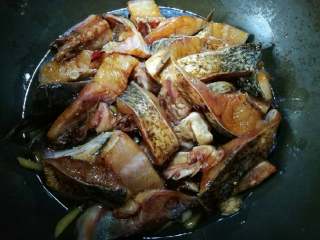 啤酒鱼,放入腌至好的鱼块连拌料一块儿倒入，轻轻摇动鱼块并调至中小火。