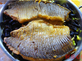铁锅烤草鱼,将炸好的鱼片，码在铁锅的配菜上面。