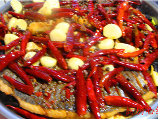 铁锅烤草鱼,最后，将锅中的红汤倒入铁锅的鱼片上面。放在电磁炉上加热煮开，直接在桌子上食用。