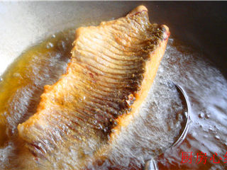 铁锅烤草鱼,擦干水分，挂一层极薄的面粉，入油锅炸成金黄色捞出。