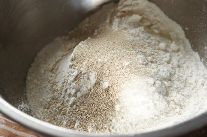 外脆里软——全程90分钟的免揉欧包,将3杯面粉，糖，盐和2汤匙即发酵母放入大碗里，很大的那种碗，最好用盆，除非材料减半