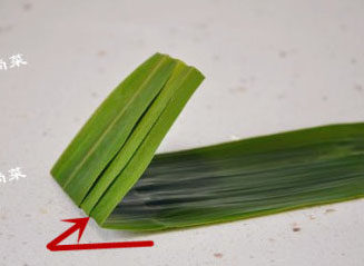 经典四角粽子包法详解，长寿米粽子 ,取三张苇叶，并排好后在大头的一端要窝漏斗的中间点折一下，留个折痕。