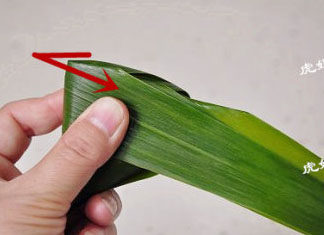 经典四角粽子包法详解，长寿米粽子 ,苇叶沿着第一步的折痕，向右边折起，形成第四个角，这样就已经成粽了。