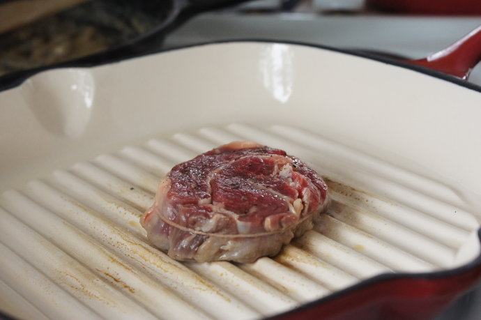 基础牛排——新西兰安格斯肉眼牛排,铸铁锅预热，放入牛排，每面煎3-5分钟，只翻面一次。