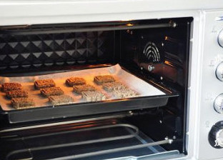 风靡网络的代餐饼-红豆薏仁茯苓饼,放入预热好的烤箱，上下管150度，15分钟，烤焙至饼干颜色稍有金黄即可。